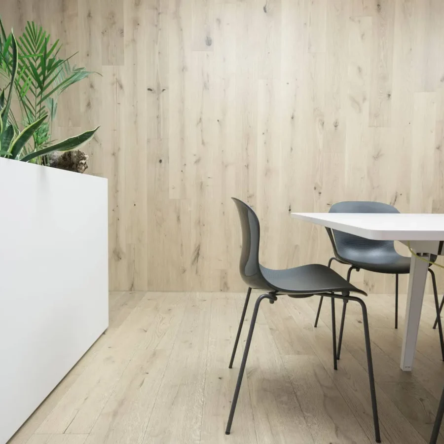 Moderner Besprechungsraum mit Fritz Hansen Stühlen, weißem Tisch, Holzverkleidung und Pflanzen in weißem, Referenz
