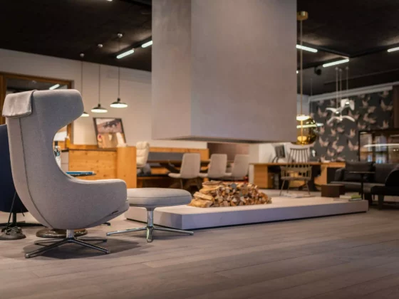 Moderner Showroom mit Minotti Poliform Sesseln, Kamin mit Holzstapel, Designermöbeln und wohnlicher Innenarchitektur
