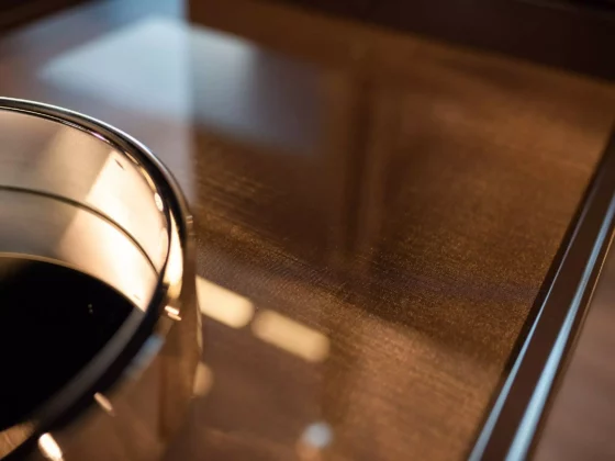 Nahaufnahme eines glänzenden Minotti Couchtischs mit Glasplatte im modernen Möbelstudio mit Innenarchitektur und