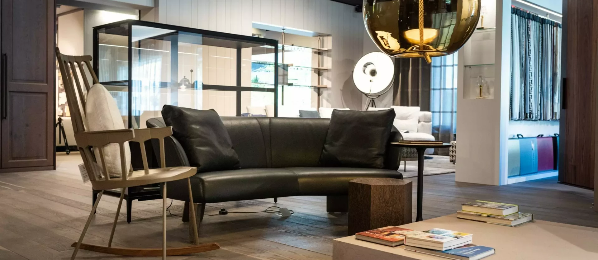 Moderner Showroom mit Poliform Sofa, Minotti Schaukelstuhl, Kartell Hängeleuchte und Riva1920 Couchtisch, stilvolle