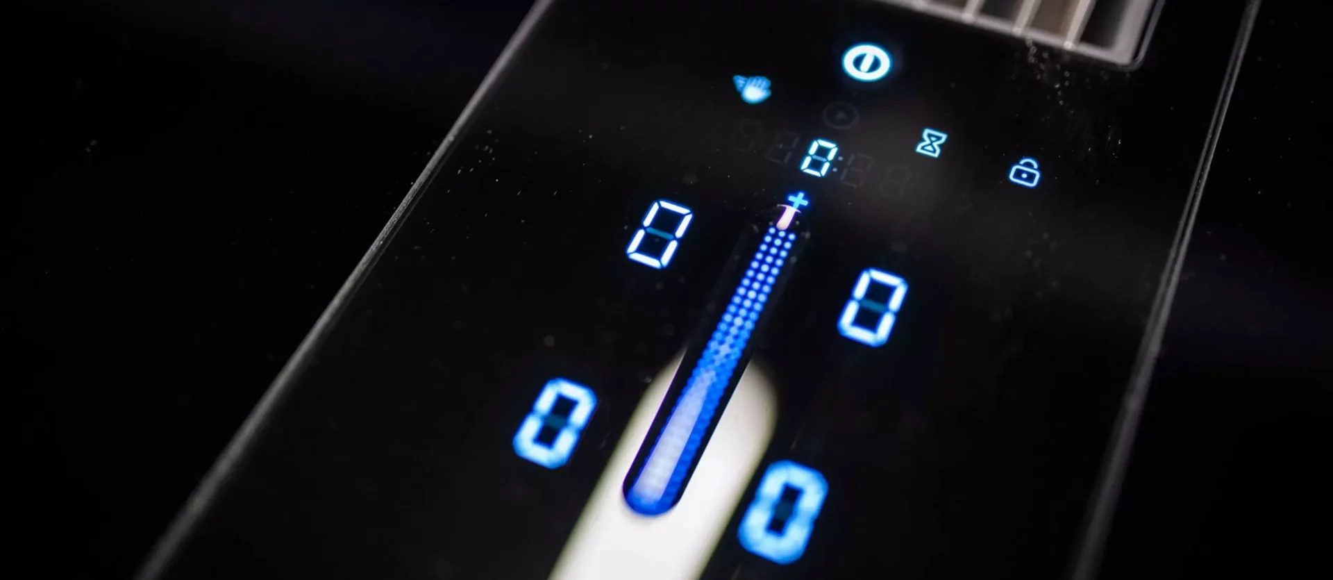 Nahaufnahme eines digitalen Bedienfelds einer Poliform Alea Küche mit blauer LED-Anzeige und Touch-Steuerung auf schwarzer