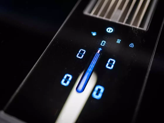 Nahaufnahme eines digitalen Bedienfelds einer Poliform Alea Küche mit blauer LED-Anzeige und Touch-Steuerung auf schwarzer