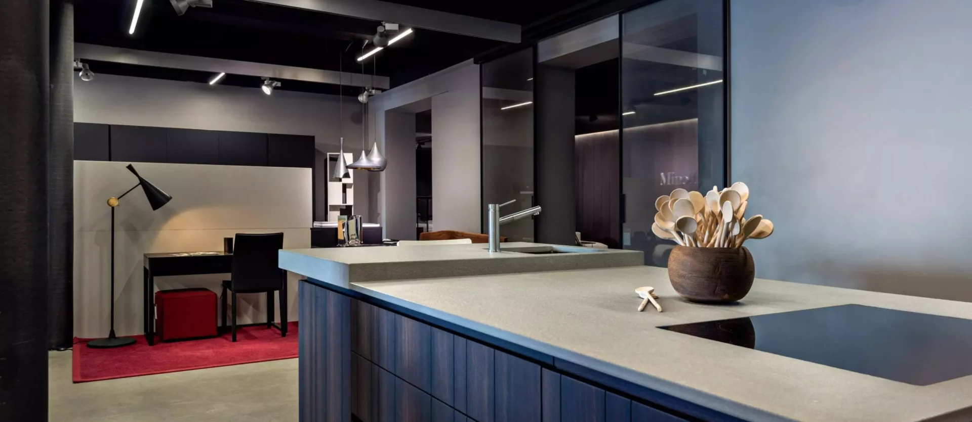 Moderne Kücheninsel mit Holzfronten und grauer Arbeitsplatte im Showroom der Tischlerei Altenmarkt mit, Innenarchitekt