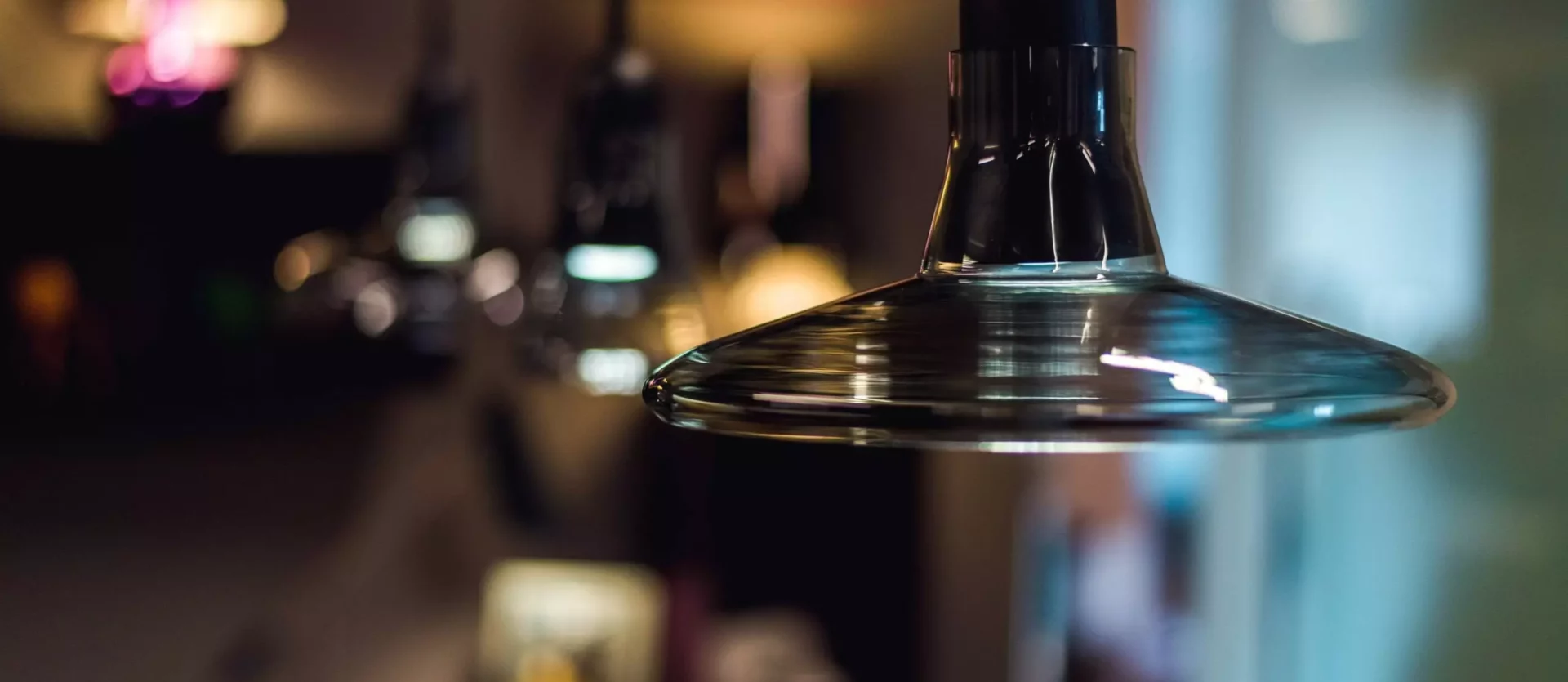 Nahaufnahme einer modernen, transparenten Hängelampe aus Glas in einem stilvollen Innenraum mit unscharfem, Innenarchitekt