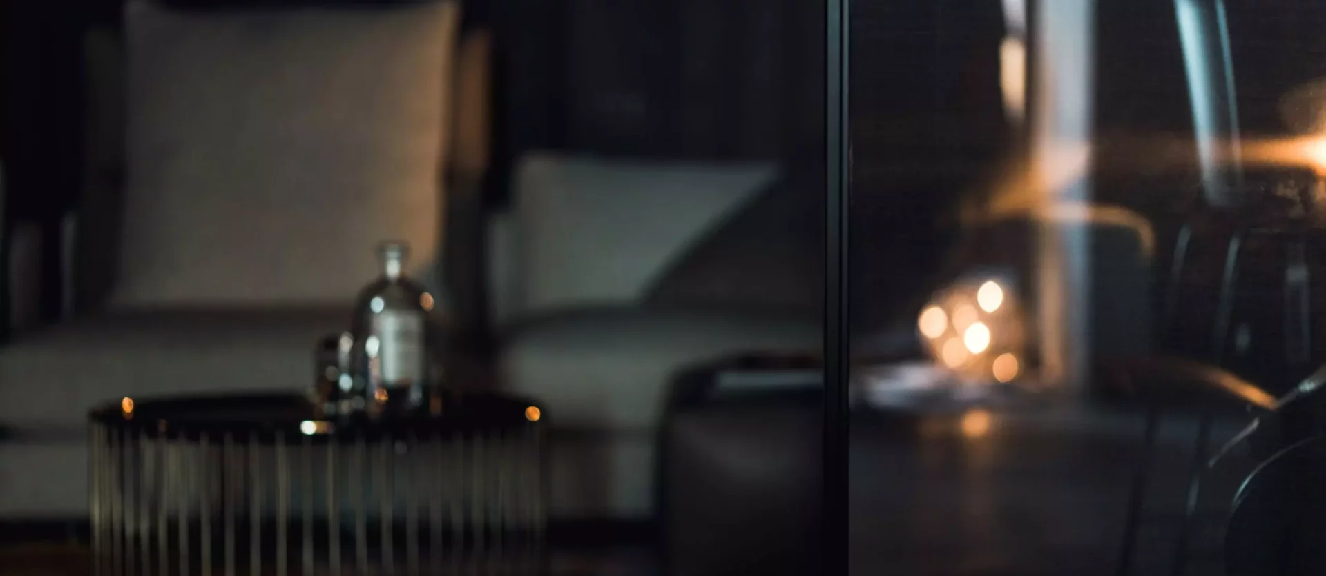 Dunkles Wohnzimmer mit bequemen Sesseln, modernem Metall-Couchtisch und stimmungsvoller Beleuchtung im, Innenarchitekt