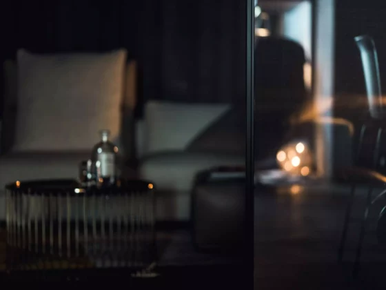 Dunkles Wohnzimmer mit bequemen Sesseln, modernem Metall-Couchtisch und stimmungsvoller Beleuchtung im, Innenarchitekt