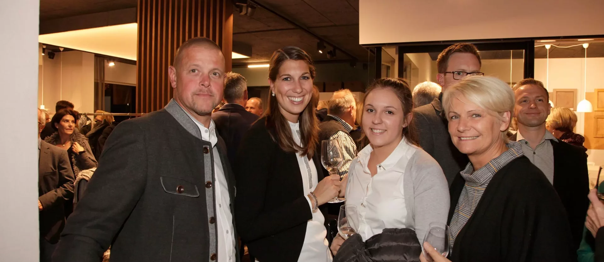 Menschen bei einer Veranstaltung im Showroom eines Möbelstudios mit Innenarchitektur- und Tischlereikonzepten, Fest