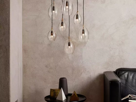 Minimalistischer Wohnraum mit sieben hängenden Glaskugel-Pendelleuchten, schwarzem Beistelltisch mit Dekoobjekten und, Möbel