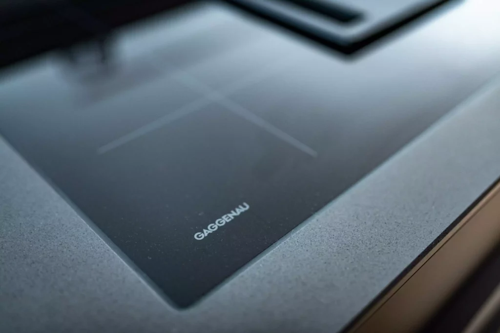 Gaggenau Induktionskochfeld in moderner schwarzer Küche mit grauer Arbeitsplatte im Möbelstudio Altenmarkt