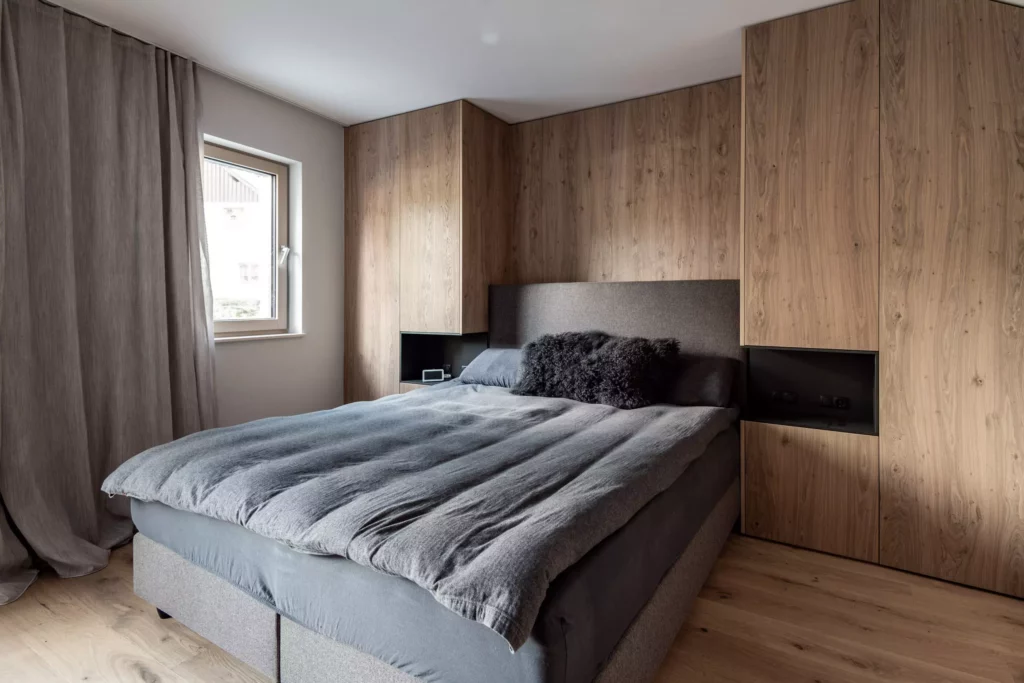 Schlafzimmer mit maßgefertigten Holzschränken und grauem Polsterbett in modernem Innenarchitektur-Design, Möbelstudio