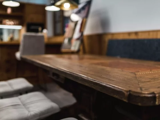 Nahaufnahme eines rustikalen Holztisches mit gepolsterten Stühlen und einer gepolsterten Bank in einem, Poliform