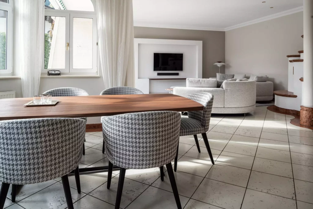 Moderner Wohnraum mit Minotti Designermöbeln, maßgefertigtem Holztisch, gepolsterten Stühlen, Teppich und Vorhängen in