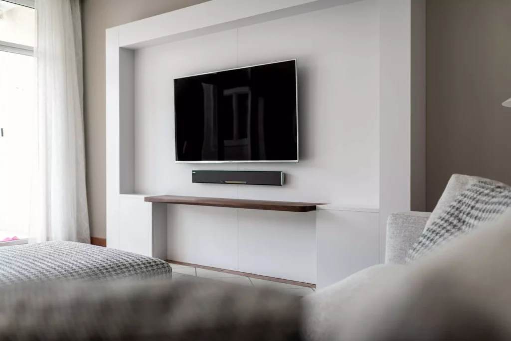 Moderner Wohnraum mit Minotti Designermöbeln, maßgefertigtem TV-Möbel mit Holzablage, Teppich und Vorhängen in Salzburg