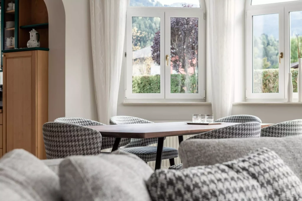 Esszimmer mit Minotti Designermöbeln, maßgefertigtem Holztisch, gepolsterten Stühlen mit Hahnentrittmuster und weißen