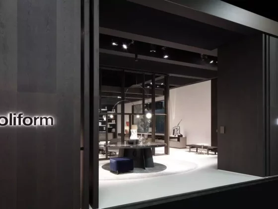 Moderner Poliform Showroom mit runder Designertisch, blauer Sitzbank und offener Raumlösung in dunkler Innenarchitektur