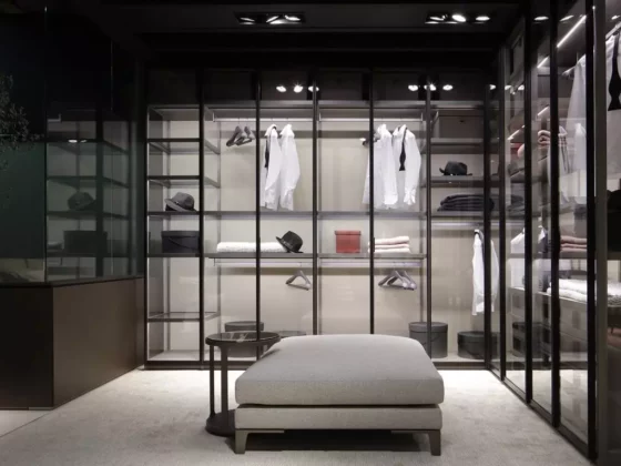 Moderne begehbare Poliform Garderobe mit Glasfronten, weißen Hemden, schwarzen Hüten, grauem Polsterhocker und integriertem