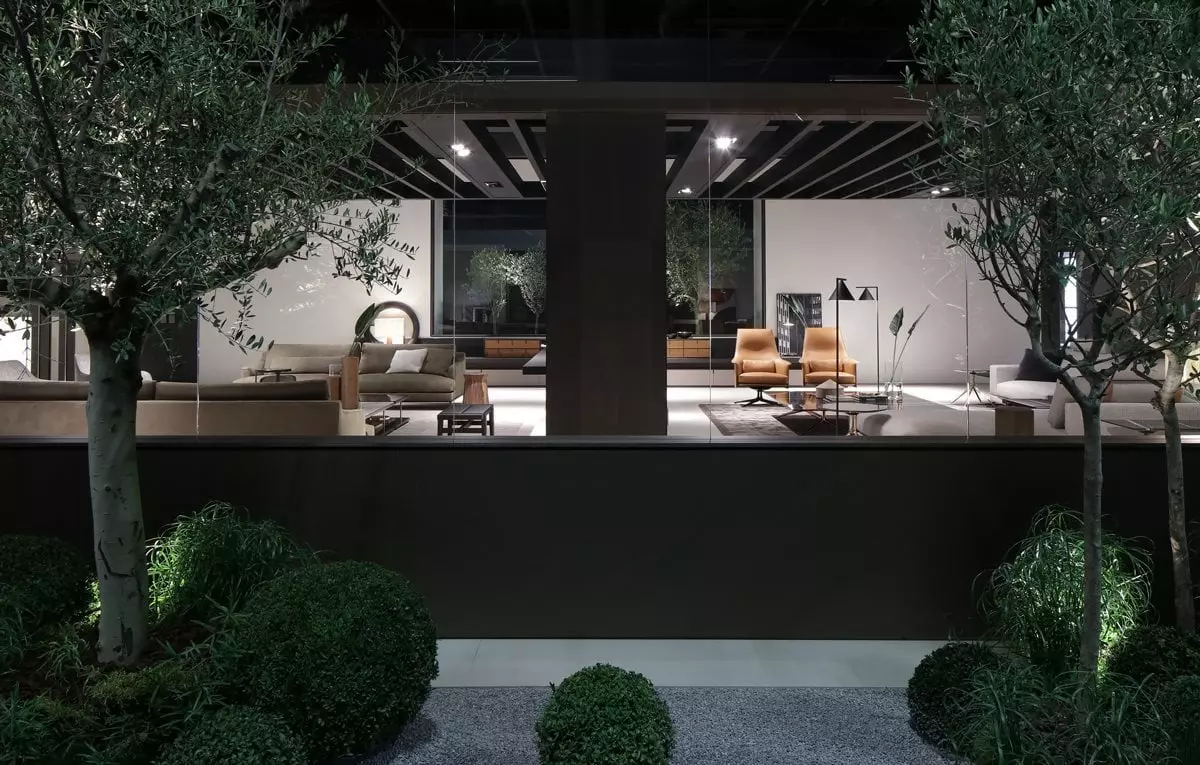 Blick durch Fenster auf modernes Wohnzimmer mit Poliform Designermöbeln, Ledersesseln, Sofas und Pflanzen bei Möbelmesse