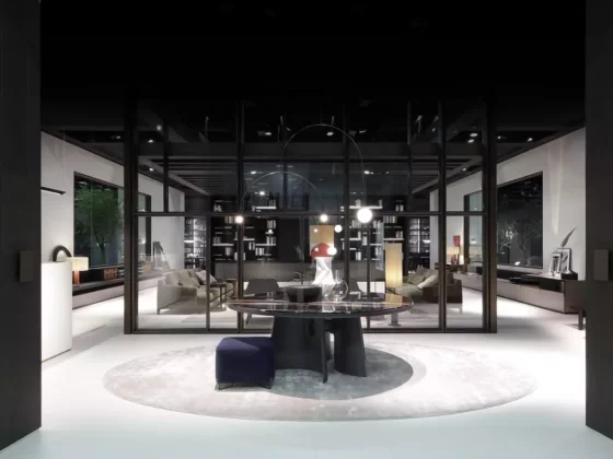 Moderner Showroom mit Poliform Designermöbeln, runder Tisch auf Teppich und Lounge-Bereich dahinter, Innenarchitektur