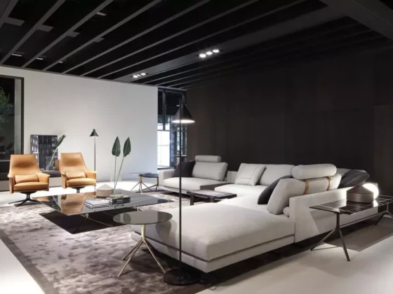 Modernes Wohnzimmer mit Poliform Sofa, zwei Ledersesseln, Couchtisch und Stehlampen in stilvollem Showroom-Design