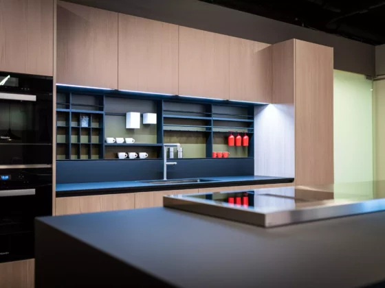 Moderne Poliform Küche Alea mit Lärchenholzfronten, schwarzer Arbeitsplatte, Induktionskochfeld und offenem Regal im