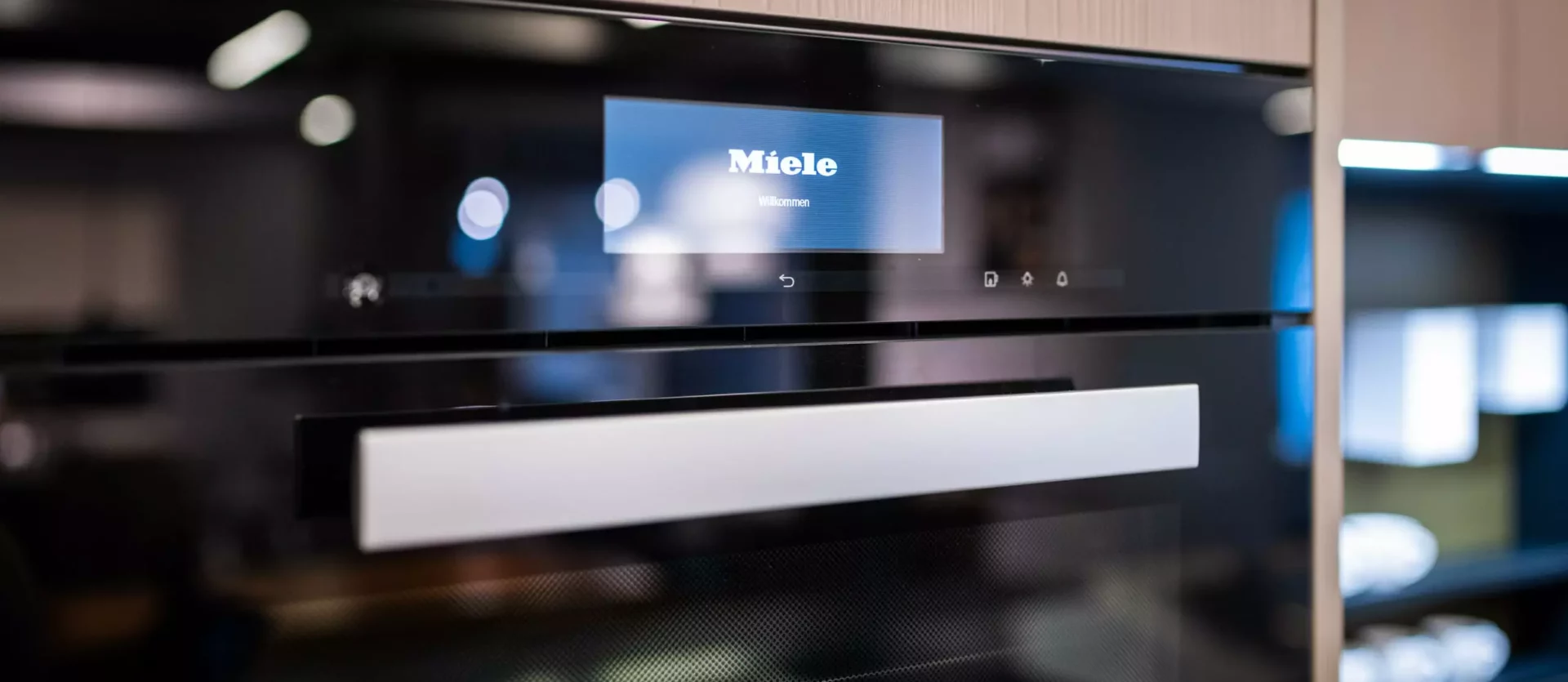 Moderne Poliform Küche mit Miele Backofen und Touchdisplay in hellem Holz und schwarzem Glas im Möbelstudio Showroom