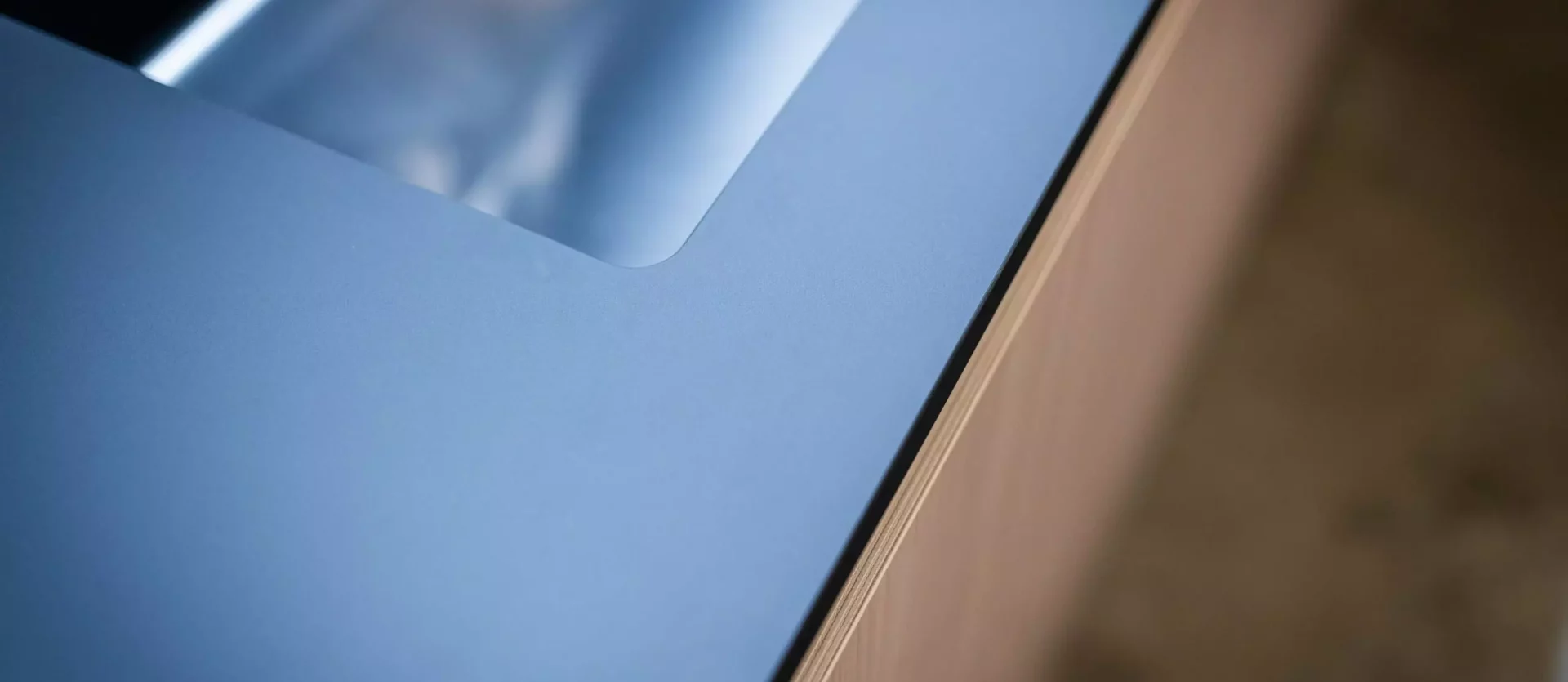 Detailaufnahme einer modernen Poliform Küche mit blauer Arbeitsplatte und integriertem Edelstahlspülbecken, maßgefertigte