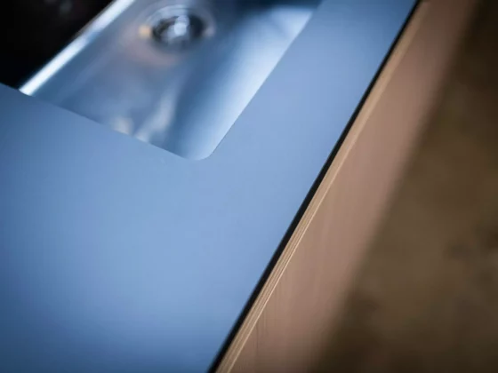 Detailaufnahme einer modernen Poliform Küche mit blauer Arbeitsplatte und integriertem Edelstahlspülbecken, maßgefertigte