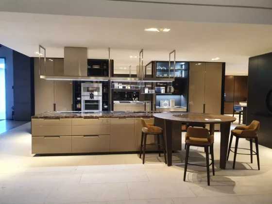 Moderne Poliform Küche mit Kochinsel, integriertem Ofen, Essbereich mit runder Holzplatte und vier Polstermöbeln im Showroom