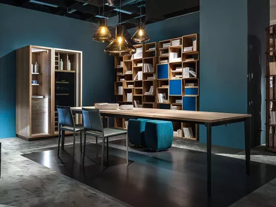 Moderner Massivholztisch von Riva1920 mit Stühlen und Hockern in stilvollem Showroom für Innenarchitektur und Möbelstudio