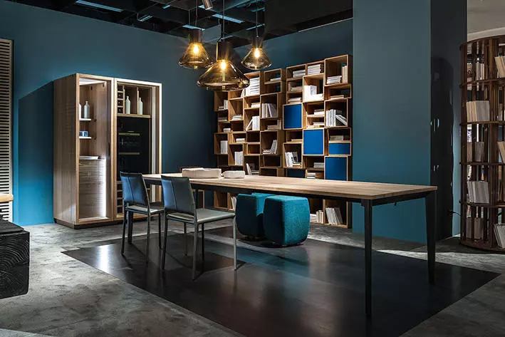 Moderner Massivholztisch von Riva1920 mit Stühlen und Hockern in stilvollem Showroom für Innenarchitektur und Möbelstudio