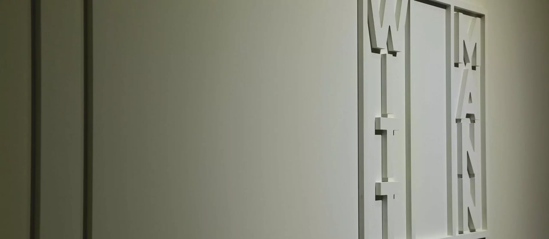 Wanddekoration mit weißen Buchstaben Wittmann in modernem Möbelstudio für Innenarchitektur und Designermöbel