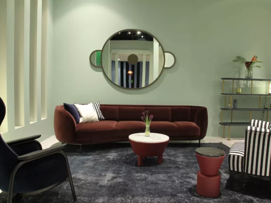 Modernes Wohnzimmer mit braunem Sofa, gestreiftem Sessel, blauem Sessel, runden Tischen und rundem Wandspiegel, Wittmann