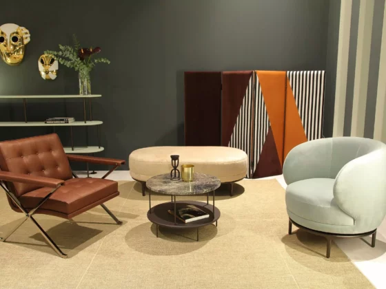 Modernes Wohnzimmer mit braunem Ledersessel, hellblauem Polstersessel, ovalem Hocker, rundem Couchtisch und, Wittmann