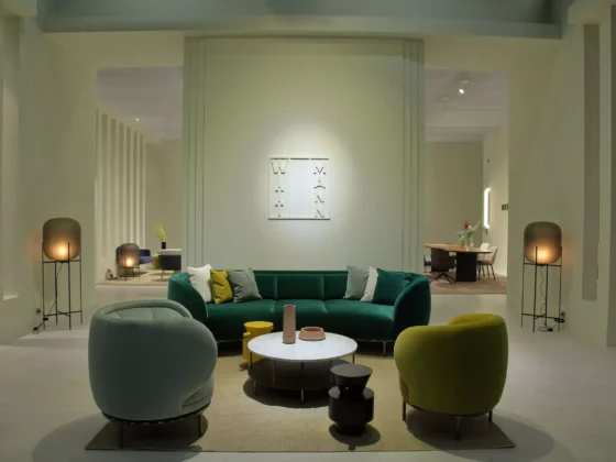 Moderner Showroom mit Wittmann Designermöbeln, grünem Sofa, zwei Sesseln, runden Tischen und stimmungsvoller Beleuchtung in
