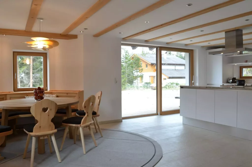 Offene Wohnküche mit maßgefertigtem Holztisch, Herzstuhl, Eckbank, moderner Kücheninsel und großen Fenstern mit, Referenzen