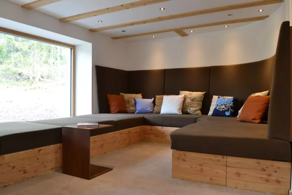 Gemütliche Eckbank mit braunen Polstern und bunten Kissen in Ferienhaus Wagrain, maßgefertigte Holzbank und, Referenzen