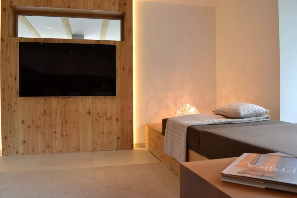 Modernes Schlafzimmer mit maßgefertigtem Holzbett, Wandverkleidung, TV und indirekter Beleuchtung im Ferienhaus, Referenzen