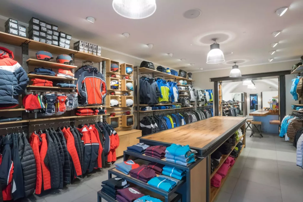 Innenarchitektur Showroom mit maßgefertigten Holzregalen und Tisch, Skibekleidung und Helmen im Lindeberg Store, Referenzen