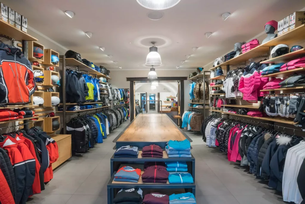 Innenarchitektur Showroom mit maßgefertigten Holzregalen und Tisch, präsentiert Skibekleidung und Helme in, Referenzen