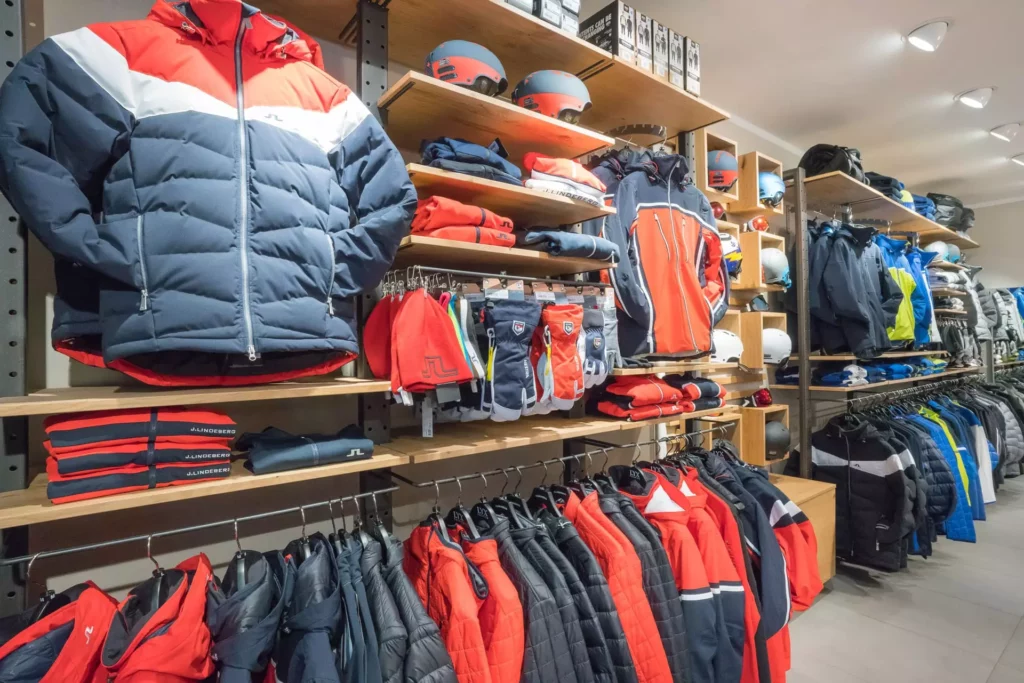 Skibekleidung und Accessoires in einem Laden mit Holzregalen und moderner Innenarchitektur, Marken J.Lindeberg, Referenzen