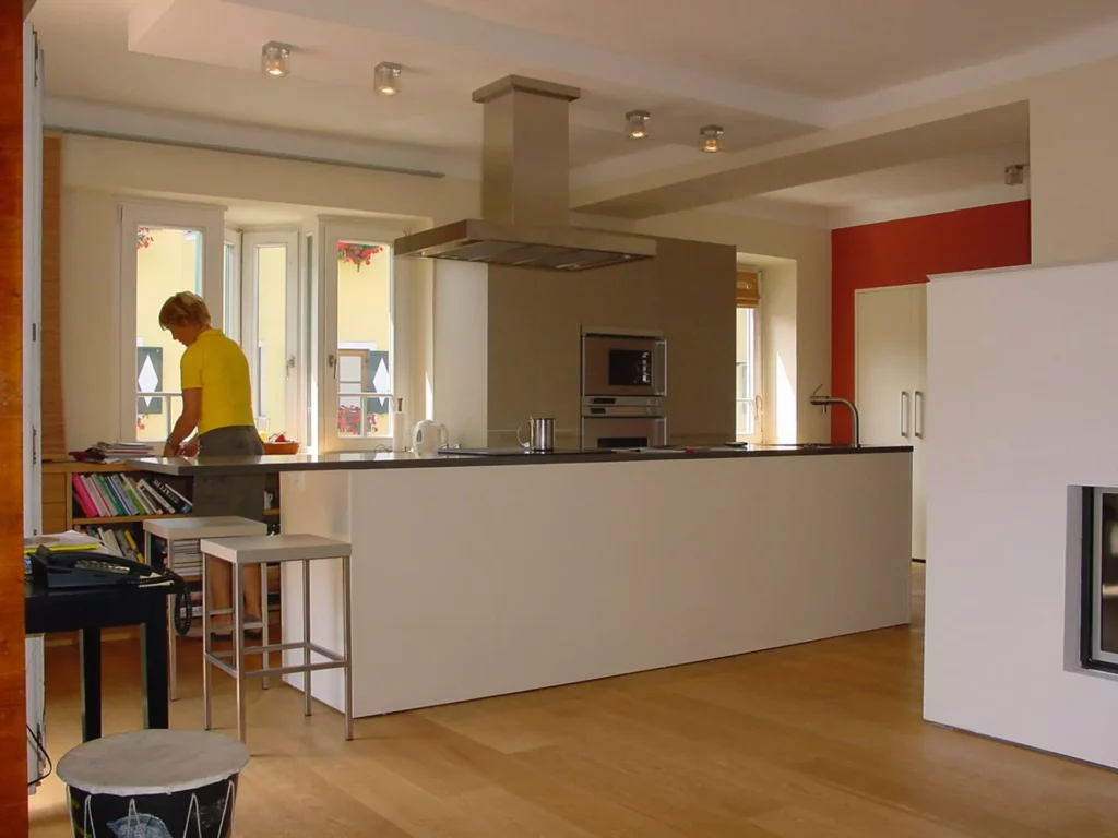 Moderne Poliform Küche mit Kochinsel, Dunstabzug, Einbaugeräten und Holzfußboden in offenem Wohnraum mit Person, Referenzen