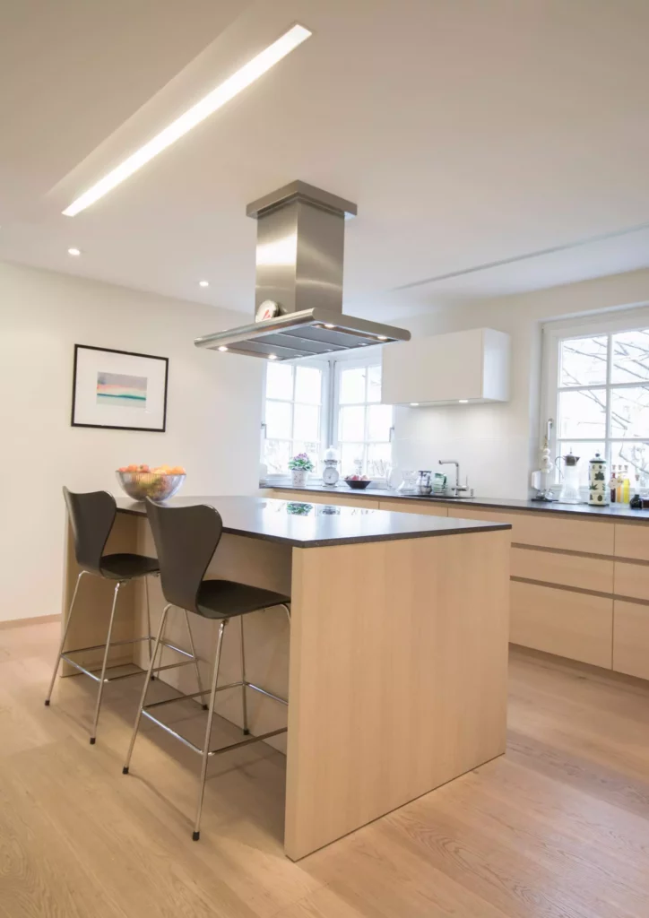 Moderne Poliform Küche in hellem Holz mit Kochinsel, Barhockern und Edelstahl-Dunstabzug in offenem Wohnraum, Referenzen