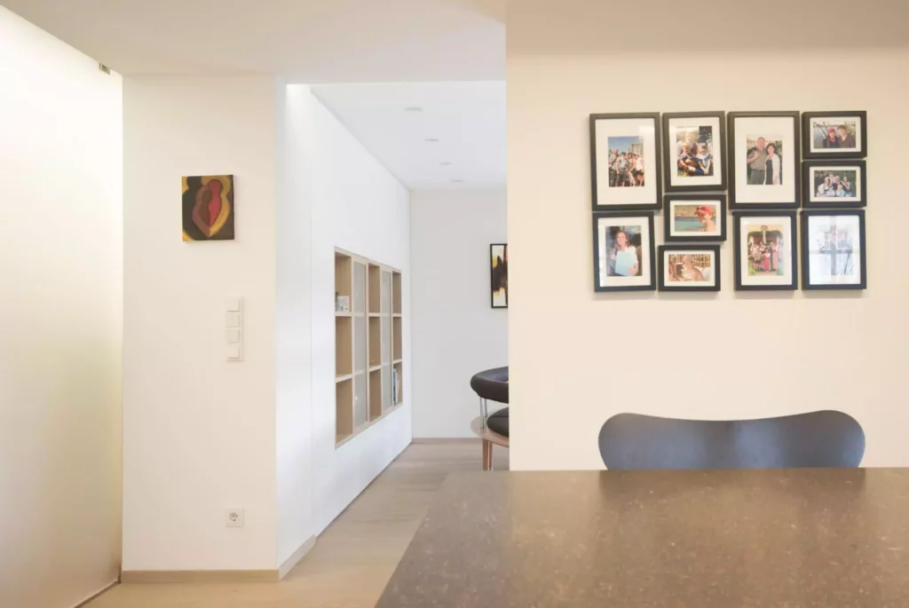 Moderner Wohnraum mit Poliform Möbeln, Wandregal, Familienfotos und schlichtem Designermöbelstuhl in hellem, Referenzen