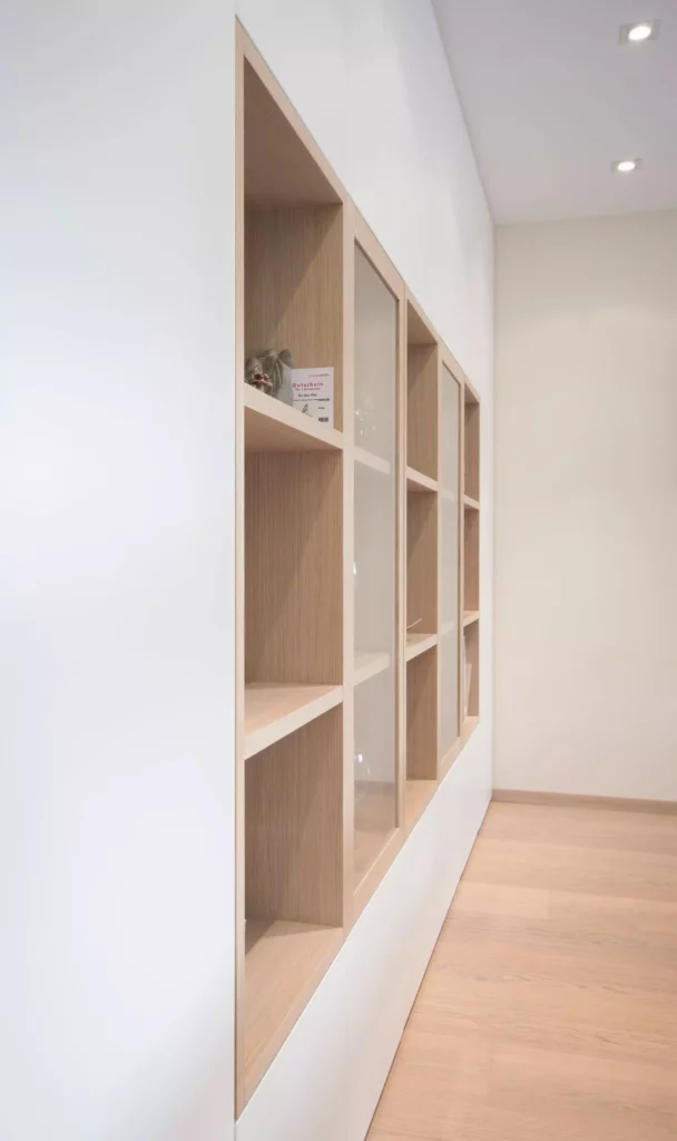Maßgefertigte Poliform Wandregale aus hellem Holz mit Glasfronten in modernem Innenraum mit hellem Parkettboden, Referenzen