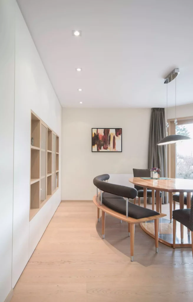 Moderner Essbereich mit Poliform Tisch, gebogener Sitzbank mit schwarzer Polsterung, Holzregal in Wandnische und, Referenzen