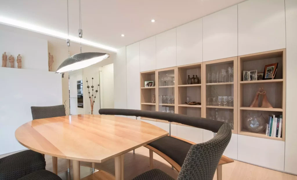 Moderner Essbereich mit maßgefertigtem Poliform-Sideboard, rundem Holztisch, gepolsterter Bank und, Referenzen