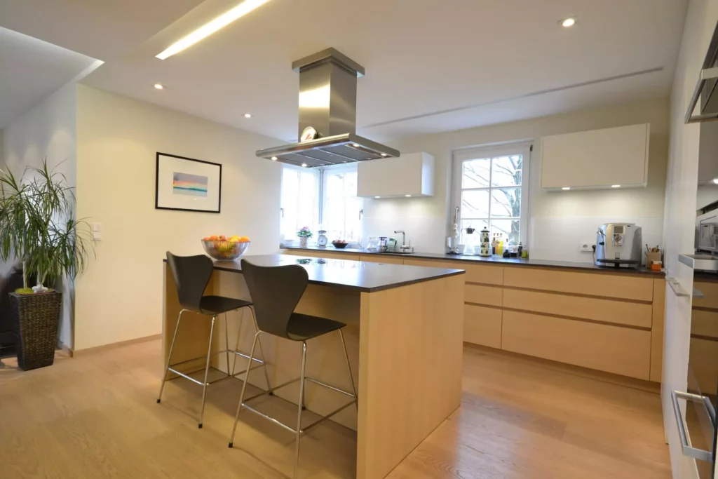 Moderne Poliform Küche mit Kochinsel, Holzfronten, schwarzen Barhockern und Edelstahl-Dunstabzug in hellem, Referenzen