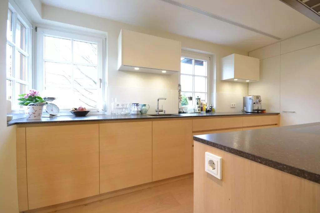 Moderne Poliform Küche mit hellen Holzfronten, schwarzen Arbeitsplatten, zwei Fenstern und integriertem, Referenzen