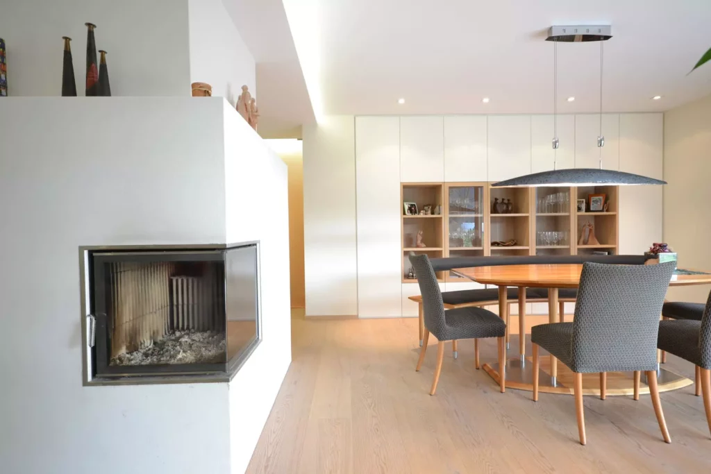 Moderner Essbereich mit Poliform Einbauküche, Holztisch, grauen Stühlen und Kamin in hellem Wohnraum, Referenzen