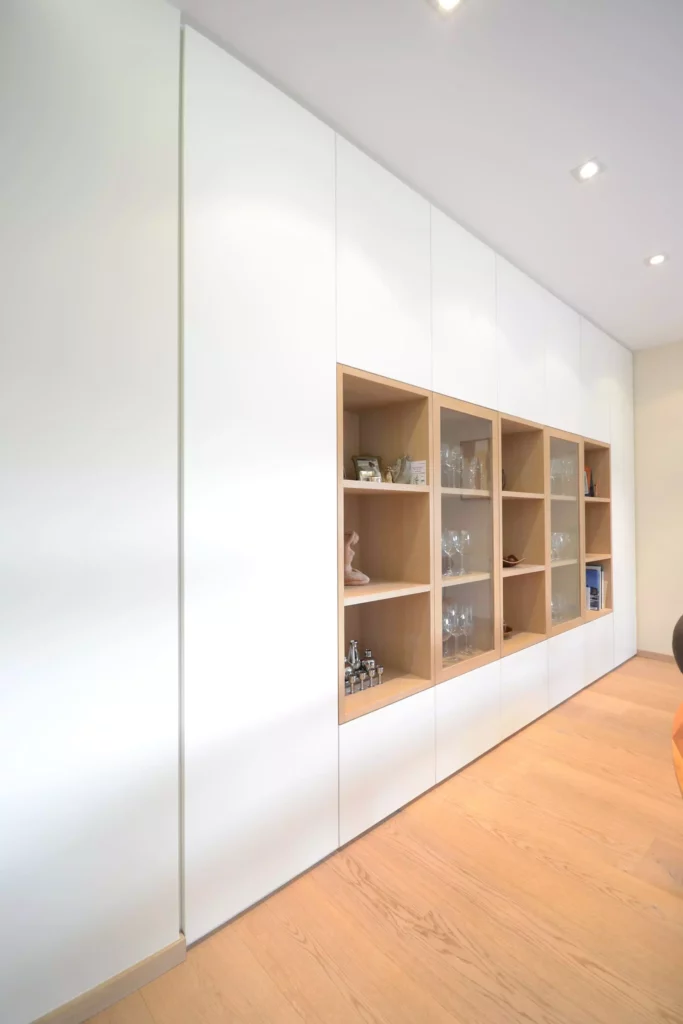 Maßgefertigte weiße Poliform Einbauwand mit offenen und verglasten Holzregalen in modernem Wohnraum mit, Referenzen